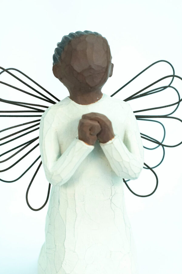 angel figurine with wire wings, praying hands, closeup