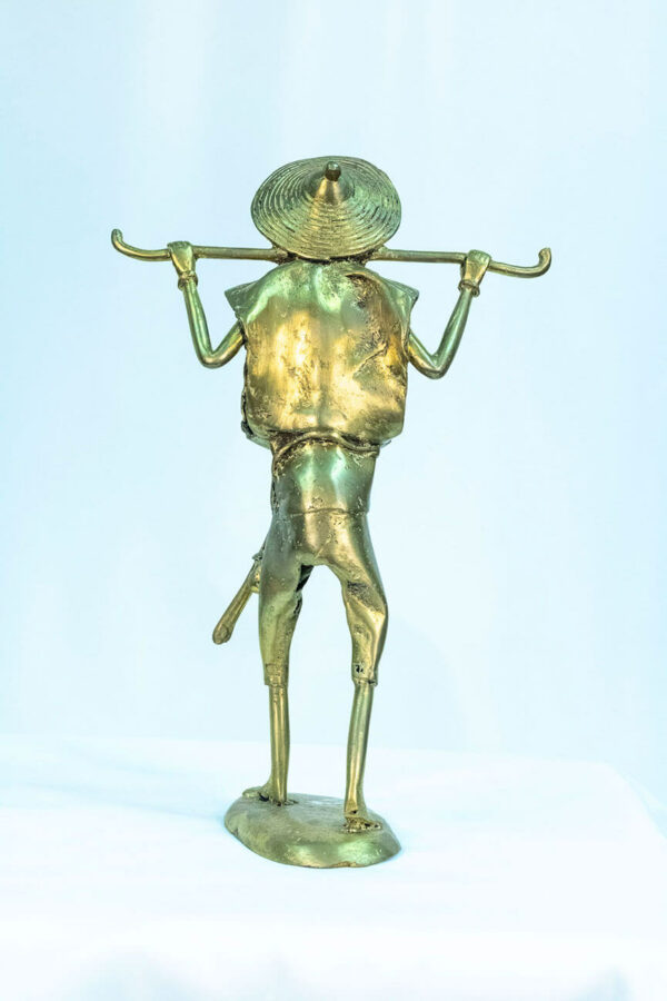 figurine, brass man holding staff over his shoulders, back