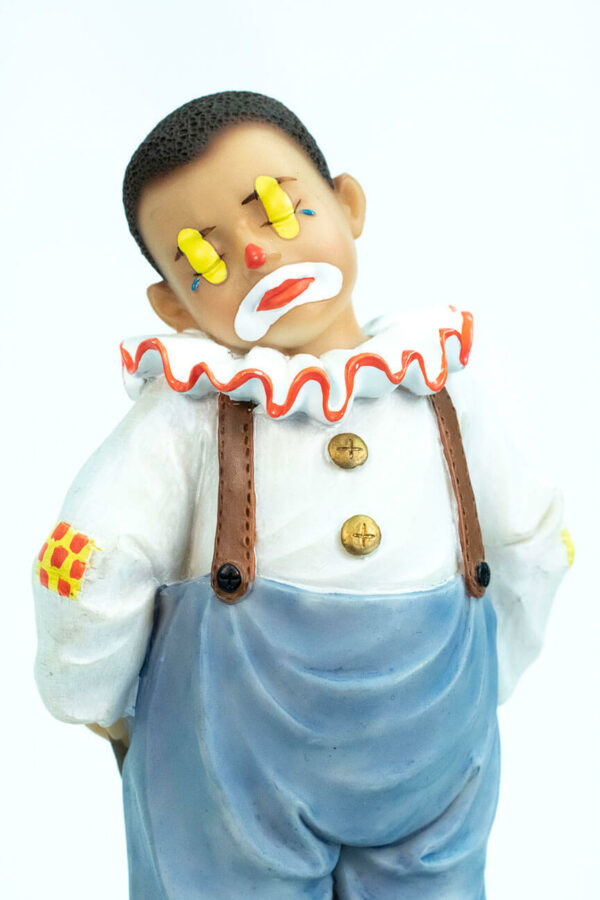 clown figurine, child clown in baggy blue pants, closeup