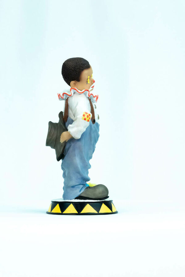 clown figurine, child clown in baggy blue pants, right