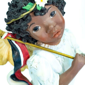 child angel figurine holding colorful flag, closeup