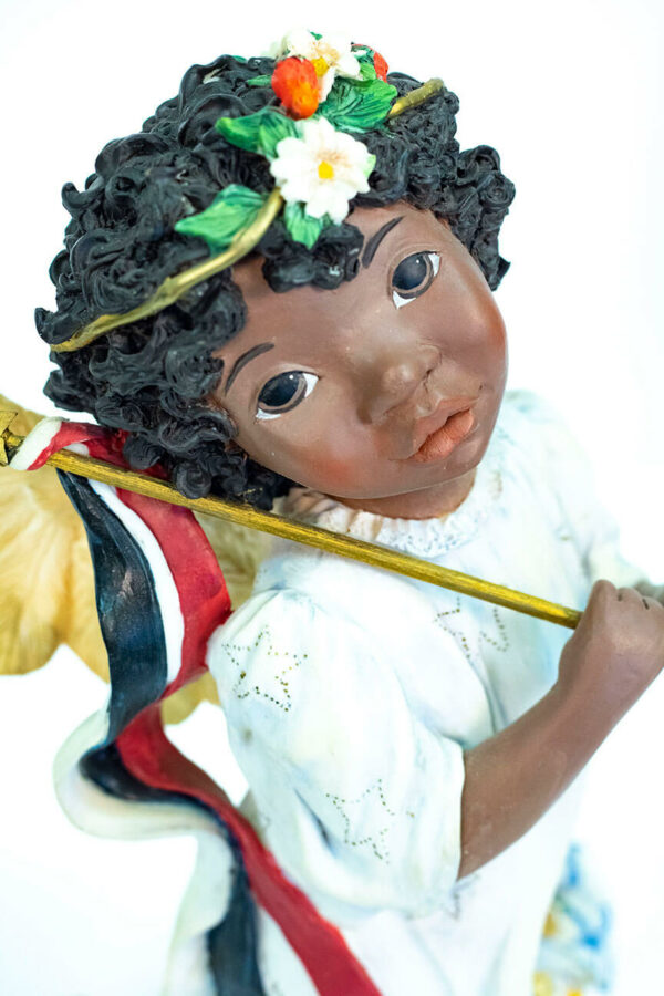 child angel figurine holding colorful flag, closeup