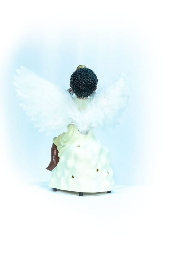 figurine, angel sitting on rock blowing horn, back