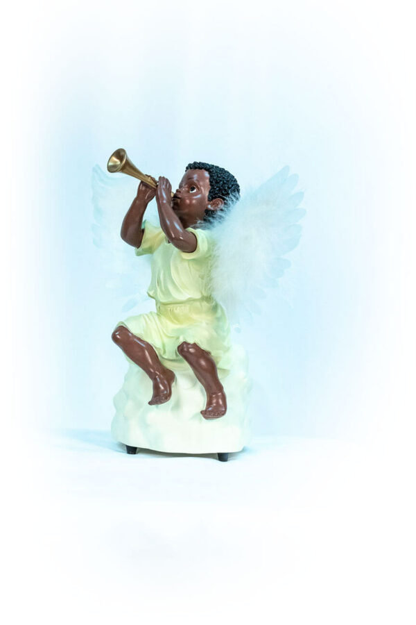 figurine, angel sitting on rock blowing horn, left