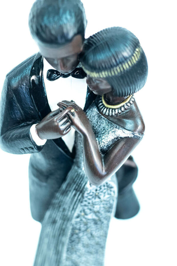 wedding couple figurine, bride and groom admire ring, closeup