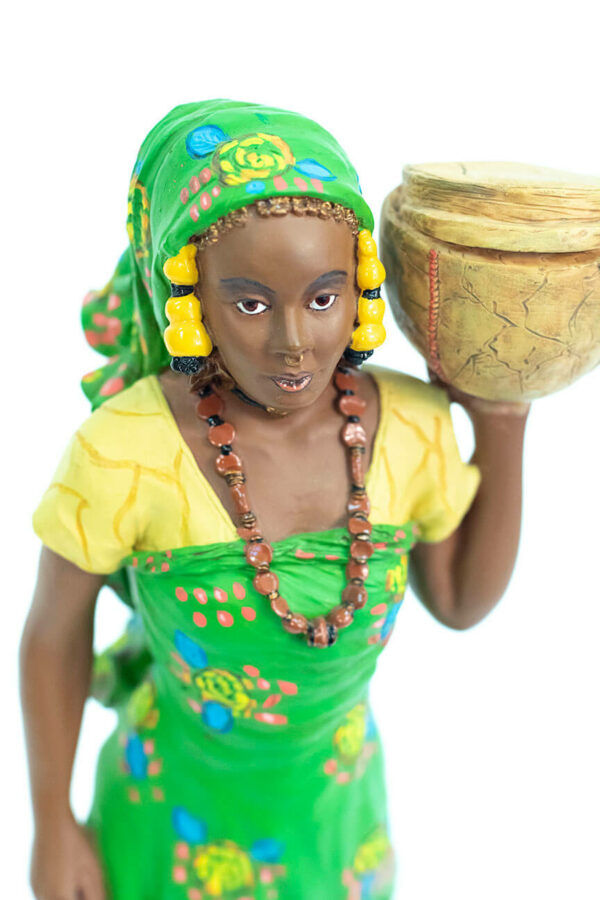 African figurine, Peul woman in green dress holding basket, closeup