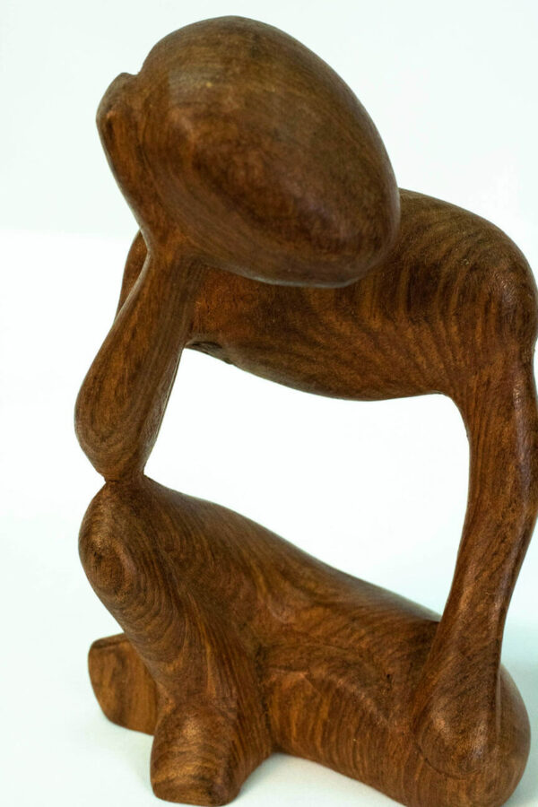 wood carving, stylistic rendering of small thinker, closeup