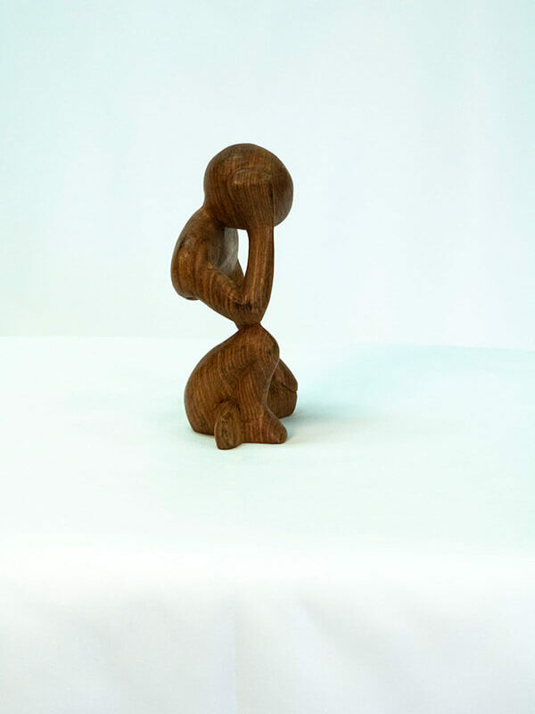 wood carving, stylistic rendering of small thinker, right