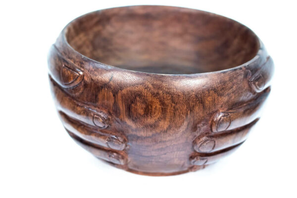 wooden bowl with hands carved on the sides, closeup