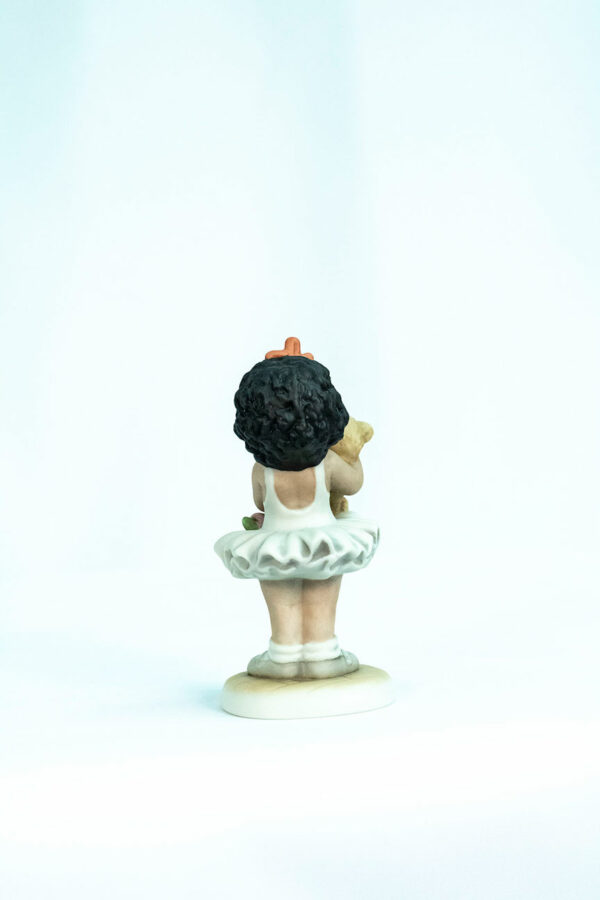 figurine, little girl holding teddy bear, back