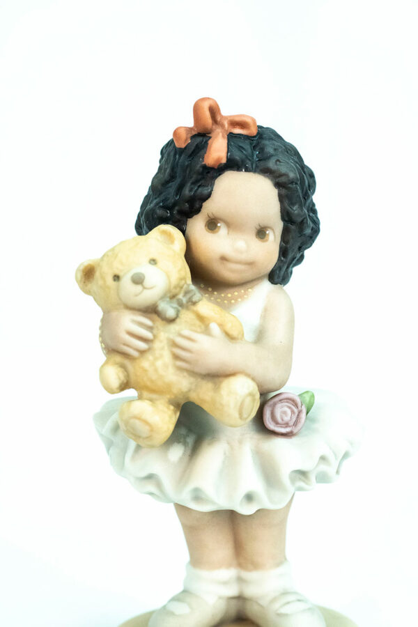 figurine, little girl holding teddy bear, closeup