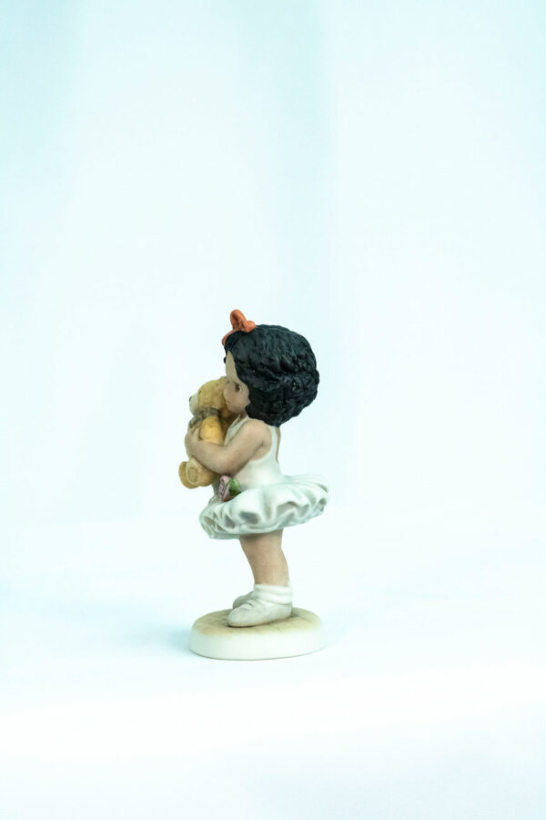 figurine, little girl holding teddy bear, left