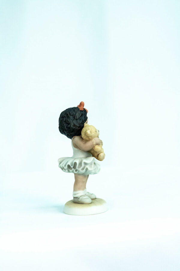 figurine, little girl holding teddy bear, right